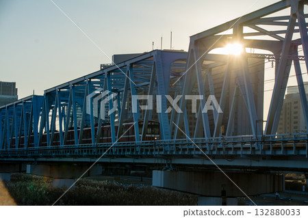 東京多摩川六號岸,一座鐵路橋在晴朗的冬日夕陽下熠熠生輝,映照著一座位於東京多摩川上的鐵路橋。 東京多摩川六號岸,一座鐵路橋在晴朗的冬日夕陽下熠熠生輝,映照著一座位於東京多摩川上的鐵路橋。 132880033
