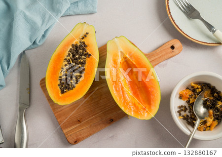 Papaya orange fruit cutted in halves, bright food photo, top view Papaya orange fruit cutted in halves, bright food photo, top view 132880167
