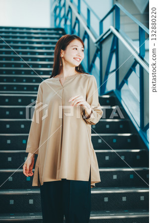 Portrait of a woman going down the stairs Portrait of a woman going down the stairs 132880220