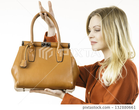 Female wearing brown dress holding bag 132880661