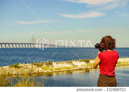 Tourist with camera and Oresund bridge Sweden. Tourist with camera and Oresund bridge Sweden. 132880721