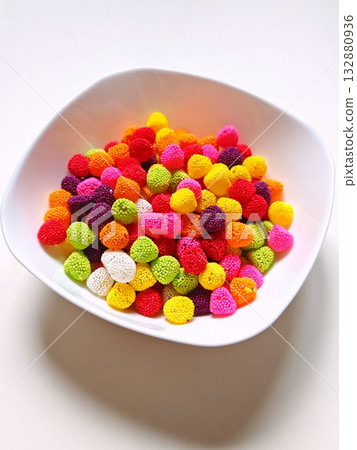Vertical. Sweet candy. Colorful candies in a white plate Vertical. Sweet candy. Colorful candies in a white plate 132880936