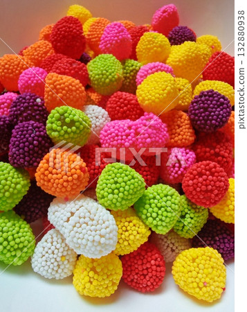 Vertical. Sweet candy. Colorful candies in a white plate 132880938