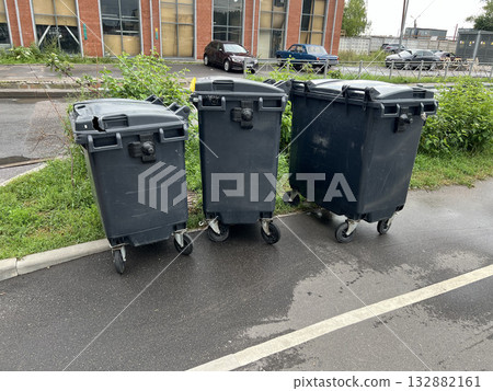Black plastic garbage cans stand on the street Black plastic garbage cans stand on the street 132882161