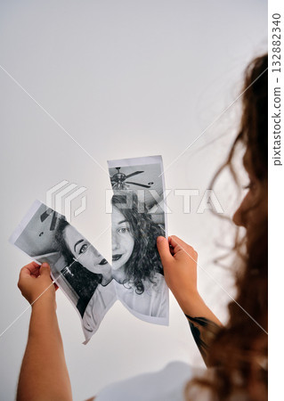 Woman holding torn half portrait representing sadness Woman holding torn half portrait representing sadness 132882340