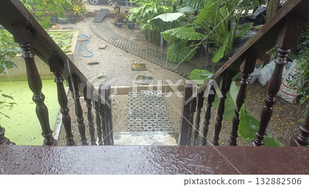 Wood stair rainy day wet railing garden view tropical plant outdoor steps mossy path serene mood wet wooden stairway overlooks 132882506