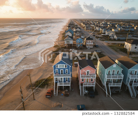 Coastal beach houses on sand at sunset warm light drone perspective serene ocean waves Coastal beach houses on sand at sunset warm light drone perspective serene ocean waves 132882584