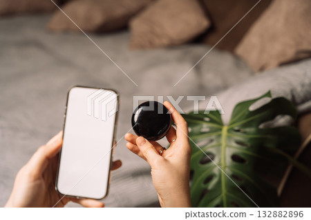 Hands pairing smartphone app with AI smart home device 132882896