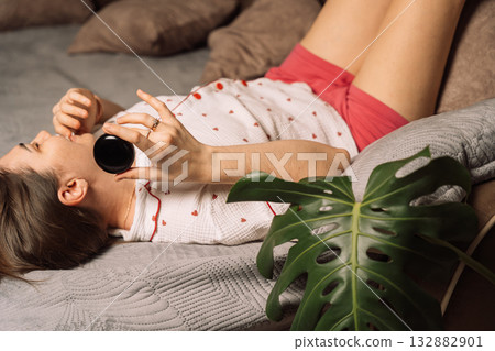 Playful woman demonstrating glossy AI smart home device 132882901