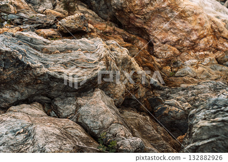 Close view of folded layered rocks along rocky shoreline 132882926