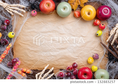 Halloween Flat Lay with Vintage Parchment, Candy Apples, Eyeball Candies, Skeleton Hands, and Spiderweb Lace 132883257