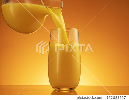Orange juice pouring into glass with splash and copy space 132883537