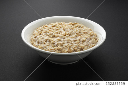 Bowl of oatmeal on black background, oat porridge breakfast 132883539