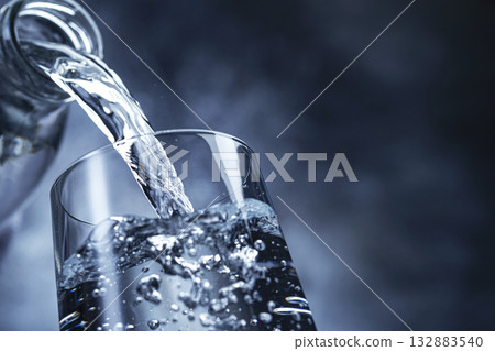 Pouring water on black background with copy space Pouring water on black background with copy space 132883540