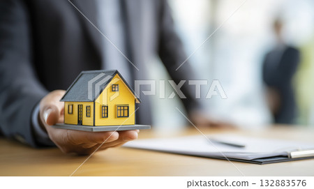 Real estate agent house model hand office contract sale modern yellow 132883576