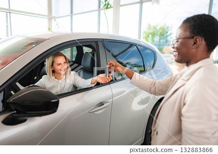 Woman buying new car at dealership getting keys 132883866