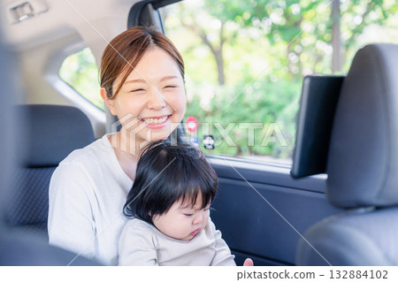 A mother riding in a taxi with her small child A mother riding in a taxi with her small child 132884102