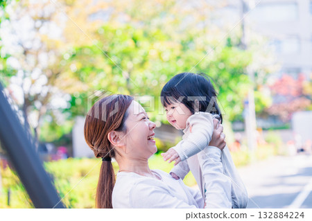 A mother laughing while holding her six-month-old baby 132884224