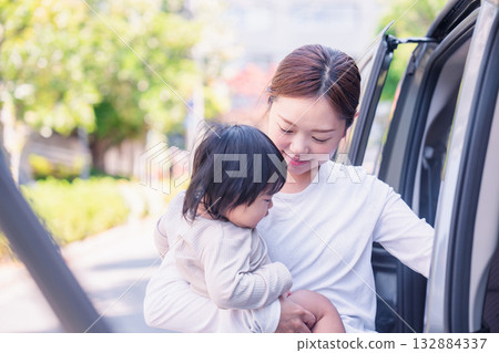 Mother riding in a car with a baby Mother riding in a car with a baby 132884337