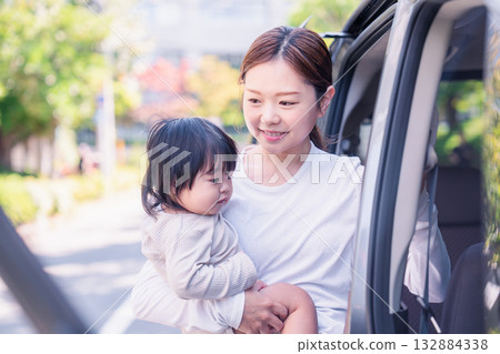 Mother riding in a car with a baby Mother riding in a car with a baby 132884338