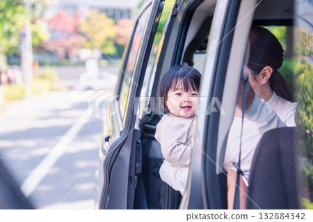 Mother riding in a car with a baby Mother riding in a car with a baby 132884342