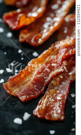 Dark moody photo of candied bacon with glossy sugar coating, ideal for illustrating sweet and salty food mashups. 132884921