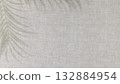 Textile Background With Neutral Linen Texture With Palm Leaf Shadows. Ideal For Eco-Friendly Product Presentation, Organic Branding, Sustainable Wellness Concepts, And Natural Aesthetic Visuals 132884954