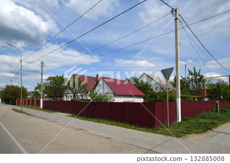 A row of one-story houses behind a metal fence, Russia A row of one-story houses behind a metal fence, Russia 132885008