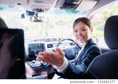 A young female taxi driver giving instructions on payment A young female taxi driver giving instructions on payment 132885177