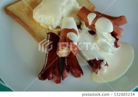 Fried frankfurters, shirred eggs and wheat toast served for breakfast Fried frankfurters, shirred eggs and wheat toast served for breakfast 132885234
