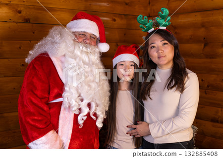 The family is posing for a picture with Santa Claus during the Christmas holiday The family is posing for a picture with Santa Claus during the Christmas holiday 132885408