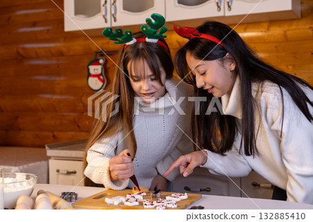 girls making Christmas cookies in a cozy kitchen girls making Christmas cookies in a cozy kitchen 132885410