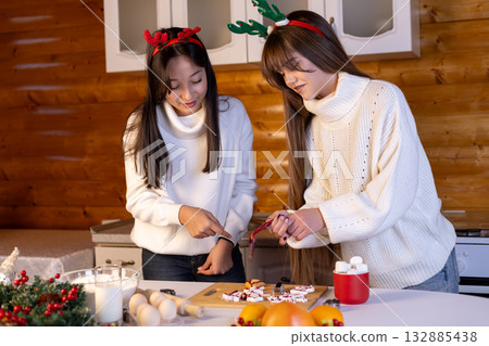 The two women are decorating Christmas cookies together 132885438