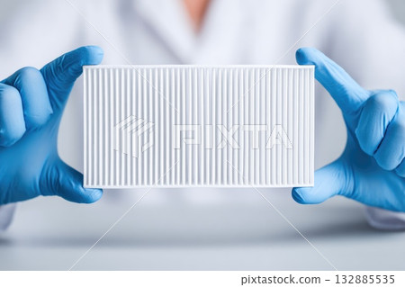 Lab technician holding white air filter 132885535