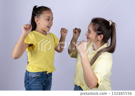 Mother and daughter are smiling and posing with their fists up 132885556