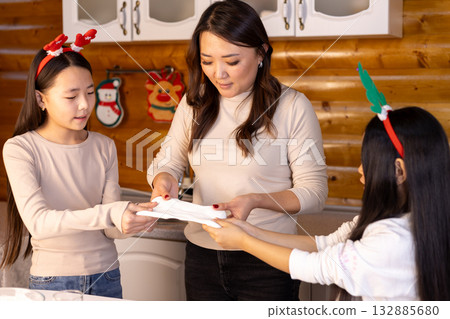 A family is preparing for Christmas in the kitchen, with the mother A family is preparing for Christmas in the kitchen, with the mother 132885680