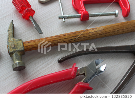 Carpentry tools and clamps are laid out on the surface of a wooden workbench Vintage worn from time and frequent used hand tools with red handles. Old tools for home workshop stock image Carpentry tools and clamps are laid out on the surface of a wooden workbench Vintage worn from time and frequent used hand tools with red handles. Old tools for home workshop stock image 132885830