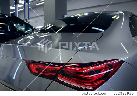 Premium class cars inside illuminated workshop bay for technical inspection  132885936