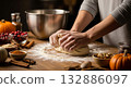 Hands kneading dough on a wooden table, preparing holiday desserts. 132886097