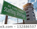 Air Traffic Control Staffing Shortage Green Road Sign In Front of Air Traffic Control Tower. 132886507