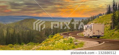 Camper Driving Down Road in The Beautiful Countryside Among Pine Trees and Flowers. Camper Driving Down Road in The Beautiful Countryside Among Pine Trees and Flowers. 132886512