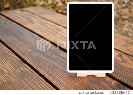 white tablet on a stand stands on a wooden table with large space for text white tablet on a stand stands on a wooden table with large space for text 132886677
