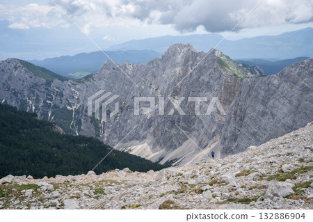 Small hiker enjoying view on vast mountainous landscape around him, Triglav National Park, Slovenia 132886904