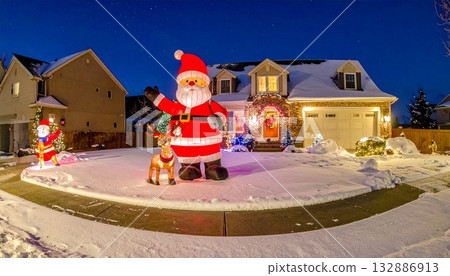 郊區的一棟房子,草坪上覆蓋著白雪,還有一個巨大的聖誕老人和馴鹿雕塑。 郊區的一棟房子,草坪上覆蓋著白雪,還有一個巨大的聖誕老人和馴鹿雕塑。 132886913
