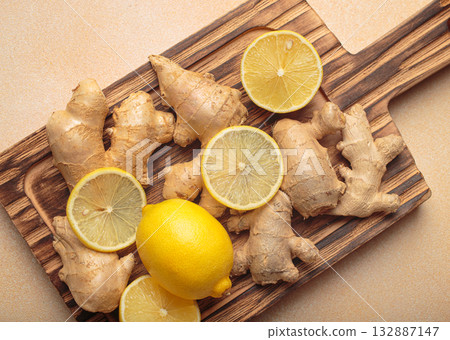 Fresh ginger roots lemon slices wooden cutting board remedy immunity light background 132887147