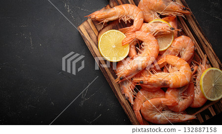 Cooked boiled shrimps lemon slices cutting board seafood dark background appetizer copy space 132887158
