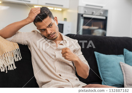 Indian man sits stressed and down after bad day holds head breathes slow and looks down in silence Indian man sits stressed and down after bad day holds head breathes slow and looks down in silence 132887182