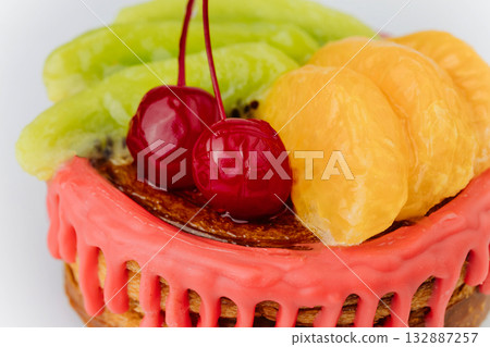 Colorful fruit pastry with red glaze, kiwi, tangerine, and cherries on white background 132887257