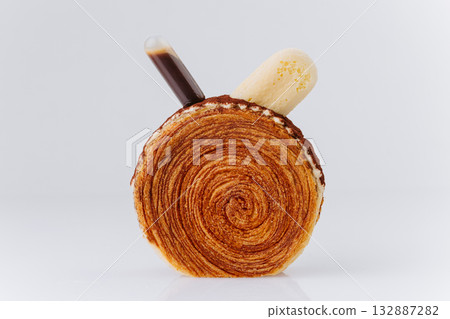 Modern tiramisu croissant roll with coffee pipette and cream topping on white background Modern tiramisu croissant roll with coffee pipette and cream topping on white background 132887282