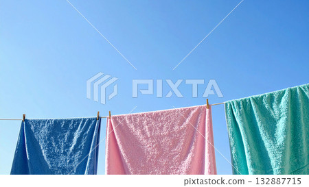 Under the blue sky, laundry sways gently in the bright sunlight, creating a serene scene that exudes cleanliness and hope. Under the blue sky, laundry sways gently in the bright sunlight, creating a serene scene that exudes cleanliness and hope. 132887715